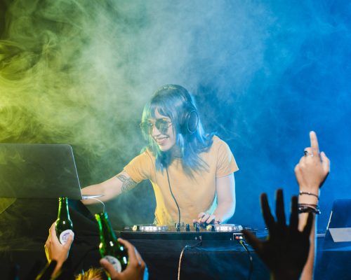 low-angle-smiley-female-dj-mixing-console low-angle-smiley-female-dj-mixing-console